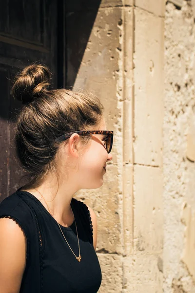 Portrait in profile of a pretty teenage girl with sunglasses