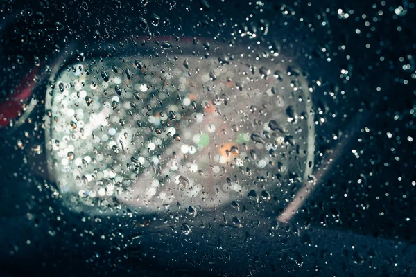 Uno specchio auto visto attraverso la finestra bagnata — Foto Stock