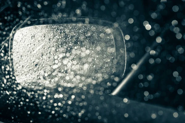 Uno specchio auto visto attraverso la finestra bagnata — Foto Stock