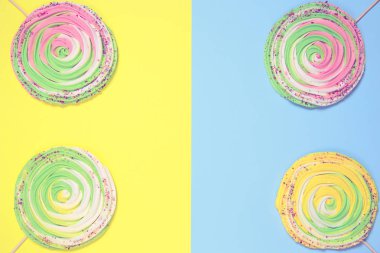 Renkli arka planda çubuklarda renkli kremalar. Şenlikli ve