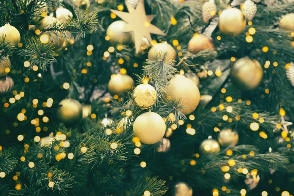Fragmento perto de uma árvore de Natal decorada com bola dourada — Fotografia de Stock