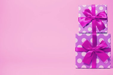 Parlak kurdeleyle boyanmış iki hediye kutusu.