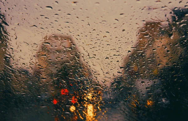 Route de la ville vue à travers les gouttes de pluie sur le pare-brise . — Photo