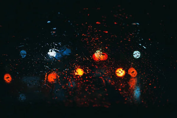 Strada comunale vista attraverso le gocce di pioggia sul parabrezza dell'auto di notte — Foto Stock