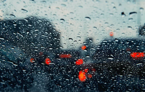 City road seen through rain drops on the car windshield . — Stock Photo, Image