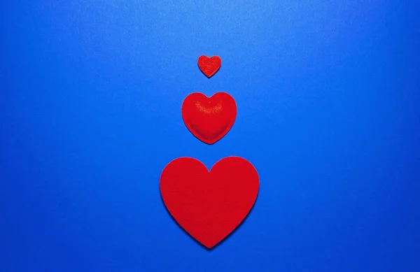 Decorative felt hearts on blue background. Abstract backdrop wit — 스톡 사진