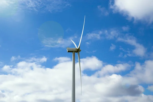 Wind turbine close up against beautiful blue sky with clouds. — Stock Photo, Image