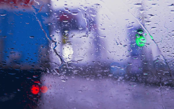 街の道路は雨を介して車のフロントガラスに値下がりしました 水の滴に焦点を当てます — ストック写真