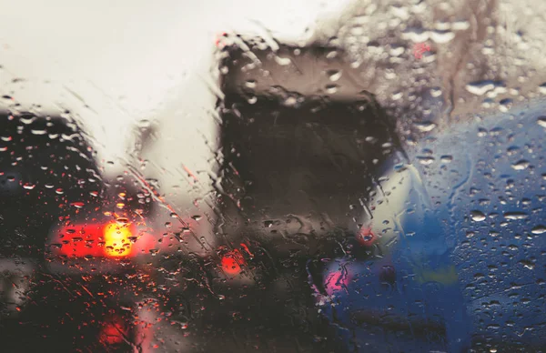 街の道路は雨を介して車のフロントガラスに値下がりしました 水の滴に焦点を当てます — ストック写真