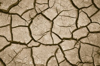 Zemin çatlamış, yakın plan. Küresel ısınma ve kuraklık kavramı. Soyut doku arkaplanı. Sepya etkisi