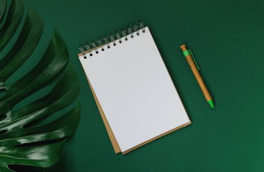 Yeşil arkaplanlı ve canavar yaprağıyla kaplı el yapımı kağıttan yapılmış not defteri. Aşk ve romantizm teması. Çevre dostu materyal kavramı.