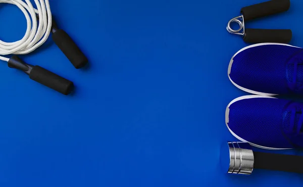 Set of sport tools and trainers on blue background. Health care concept. Flat lay. Top view