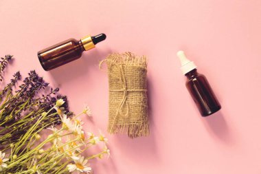 Doğal sabun seti, esaslı ya da aroma yağı şişelerde ve bitkiler pastel arka planda. Ev spa konsepti. Güzellik ritüelleri teması.