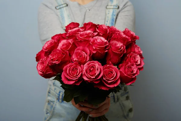 Красивая девушка в комбинезоне с красными розами — стоковое фото