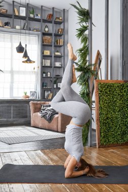 Kadın pratik gelişmiş yoga oturma odasında