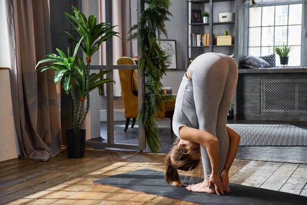 Жінка практикує розвинену йогу у вітальні — стокове фото