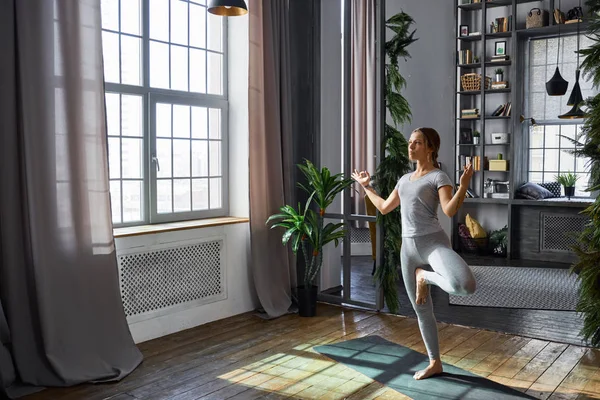 Vrouw beoefenen geavanceerde yoga in de woonkamer — Stockfoto
