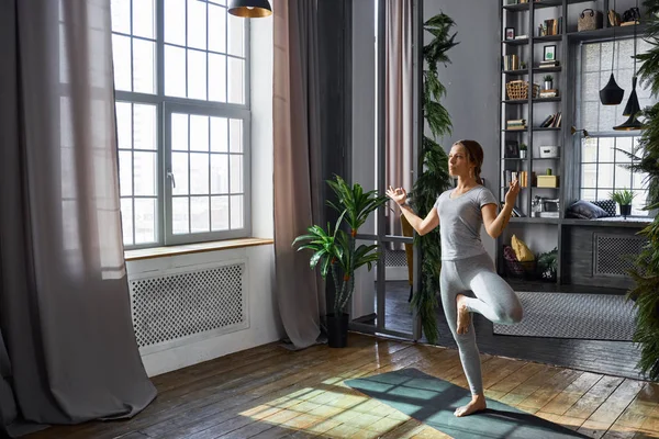 Kadın pratik gelişmiş yoga oturma odasında
