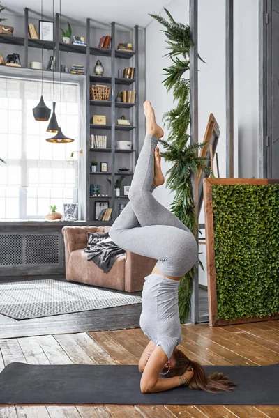 Vrouw beoefenen geavanceerde yoga in de woonkamer — Stockfoto