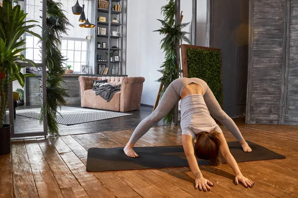 Vrouw beoefenen geavanceerde yoga in de woonkamer — Stockfoto
