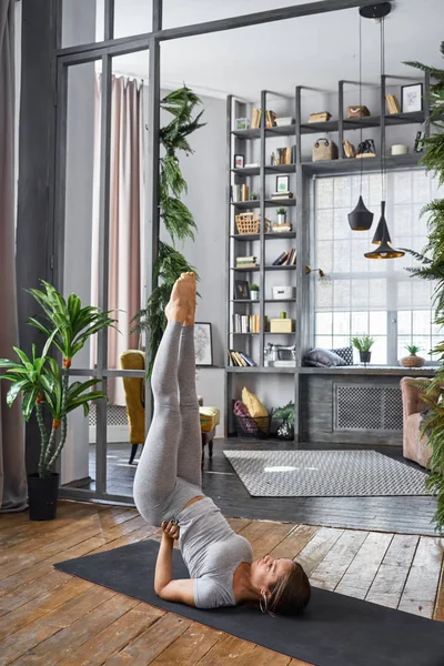 Femme pratiquant le yoga avancé dans le salon — Photo