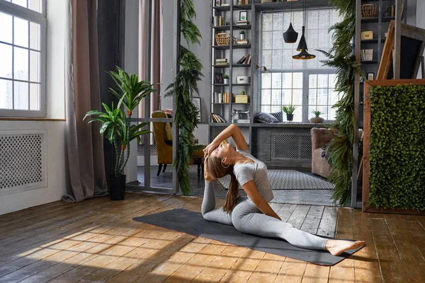 Kadın pratik gelişmiş yoga oturma odasında
