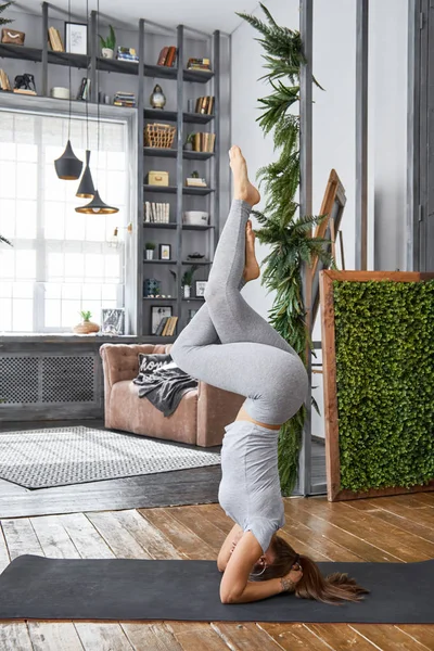 Kadın pratik gelişmiş yoga oturma odasında