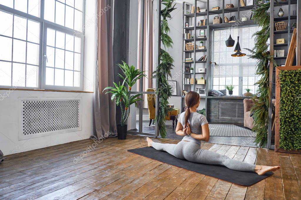 Woman practicing advanced yoga in the living room