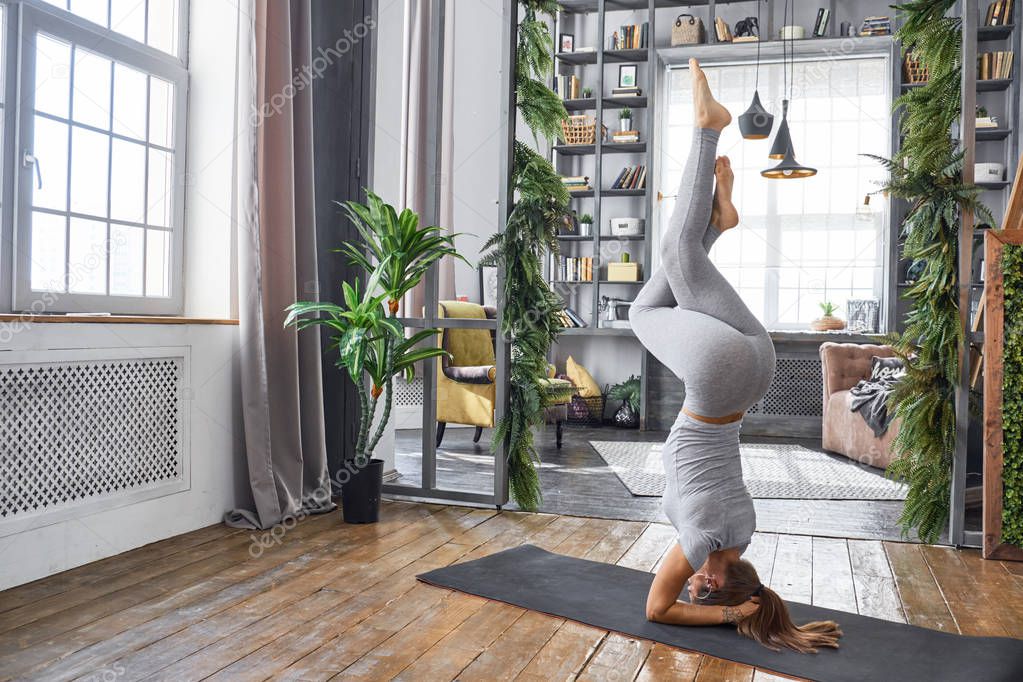 Woman practicing advanced yoga in the living room