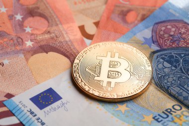 Altın bitcoins Euro banknot arka plan üzerinde yığılmış