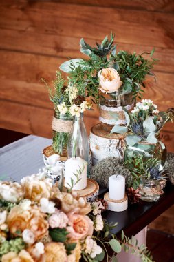 Kavanoz ve ahşap arka plan üzerinde düğün için mum taze çiçekler ile masa dekor
