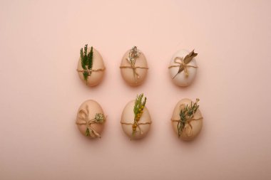 Bej renkli arka plan üzerinde dekoratif elemanları ile şık yumurta düz lay