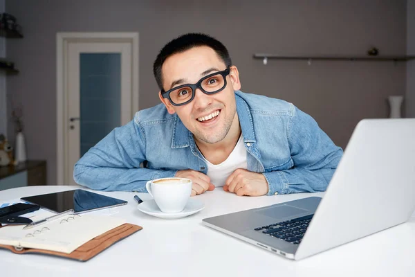 Man in glazen die op laptop vanuit huis werkt. — Stockfoto