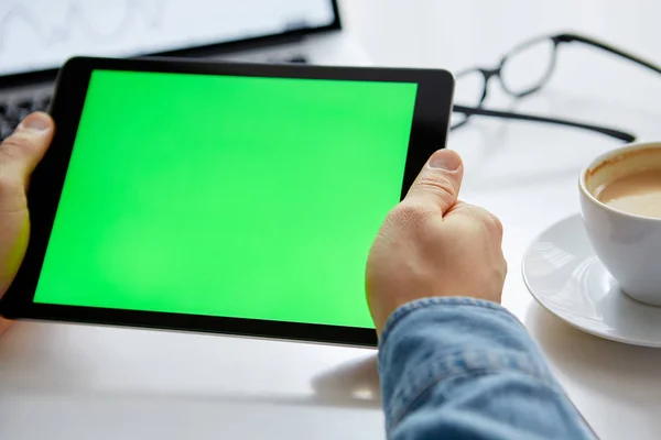 As mãos do homem com tablet com chave croma verde. Trabalho a partir de casa em um tablet — Fotografia de Stock