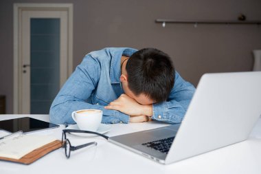 Stresli erkek laptop ve belgeler ile masada yatıyor. Sleepworking uzun junkets çaba sonra