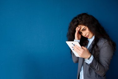 Arka plan beton duvar üzerinde elinde bir tablet kızla. Online Eğitim öğrencileri