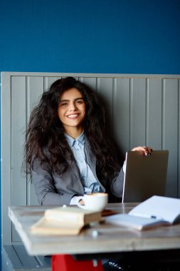 Kafede oturan ve bilgisayarda çalışan güzel esmer.