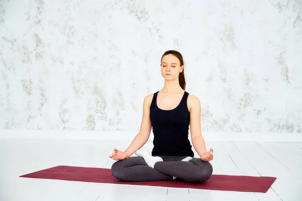 Mujer joven meditando en el interior.Una serie de posturas de yoga. Primer plano de las manos de la mujer meditando en el interior —  Fotos de Stock