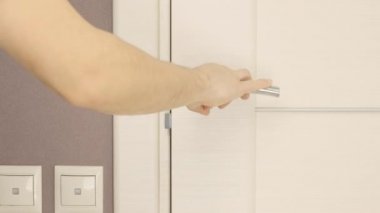 Bir adam kapı kilidini vidalamak için tornavida kullanıyor. Kilidi tamir eden adam.