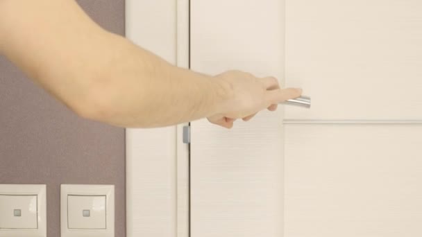 Een man gebruikt een schroevendraaier om een deurslot te schroeven. Man repareert het slot — Stockvideo