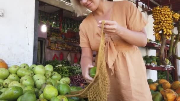 エキゾチックな農村市場で新鮮なアボカドを購入する女性 — ストック動画