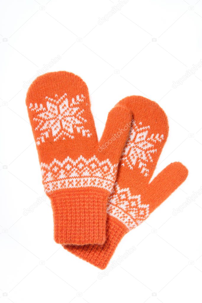 Warm woolen knitted mittens isolated on white background. Orange knitted mittens with pattern