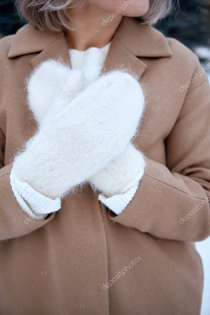 Hands in Knitted Mittens. Winter lifestyle. Wearing Stylish Warm Clothes. Woman in warm clothes