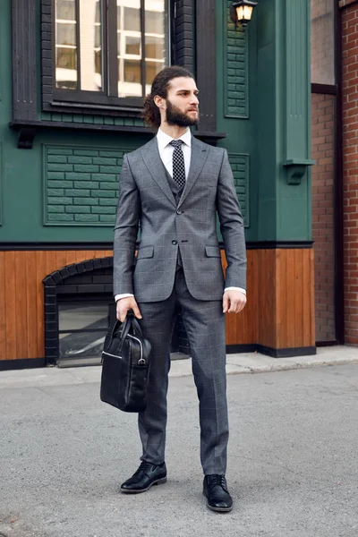 Attraente giovane barbuto in abito classico con borsa. Eleganza — Foto Stock