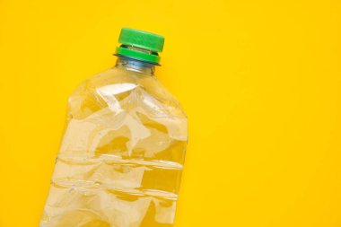 Sarı arka planda kapaklı plastik su şişesi kullanılmış. Kaydet