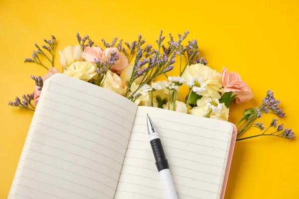 Bloc de notas rosa con flores sobre fondo amarillo. Humor de primavera — Foto de Stock
