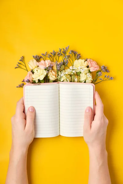 Pink Notepad with Flowers over yellow background. Spring mood