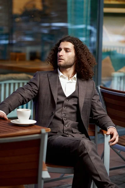 Business style. Men style. Businessman in a blue jacket with a cup of coffee