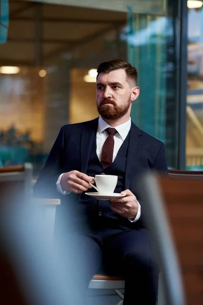 Business style. Men style. Businessman in a blue jacket with a cup of coffee