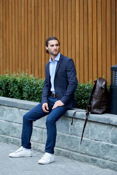 Atractivo joven barbudo en traje clásico con bolsa. Elegancia y estilo masculino —  Fotos de Stock